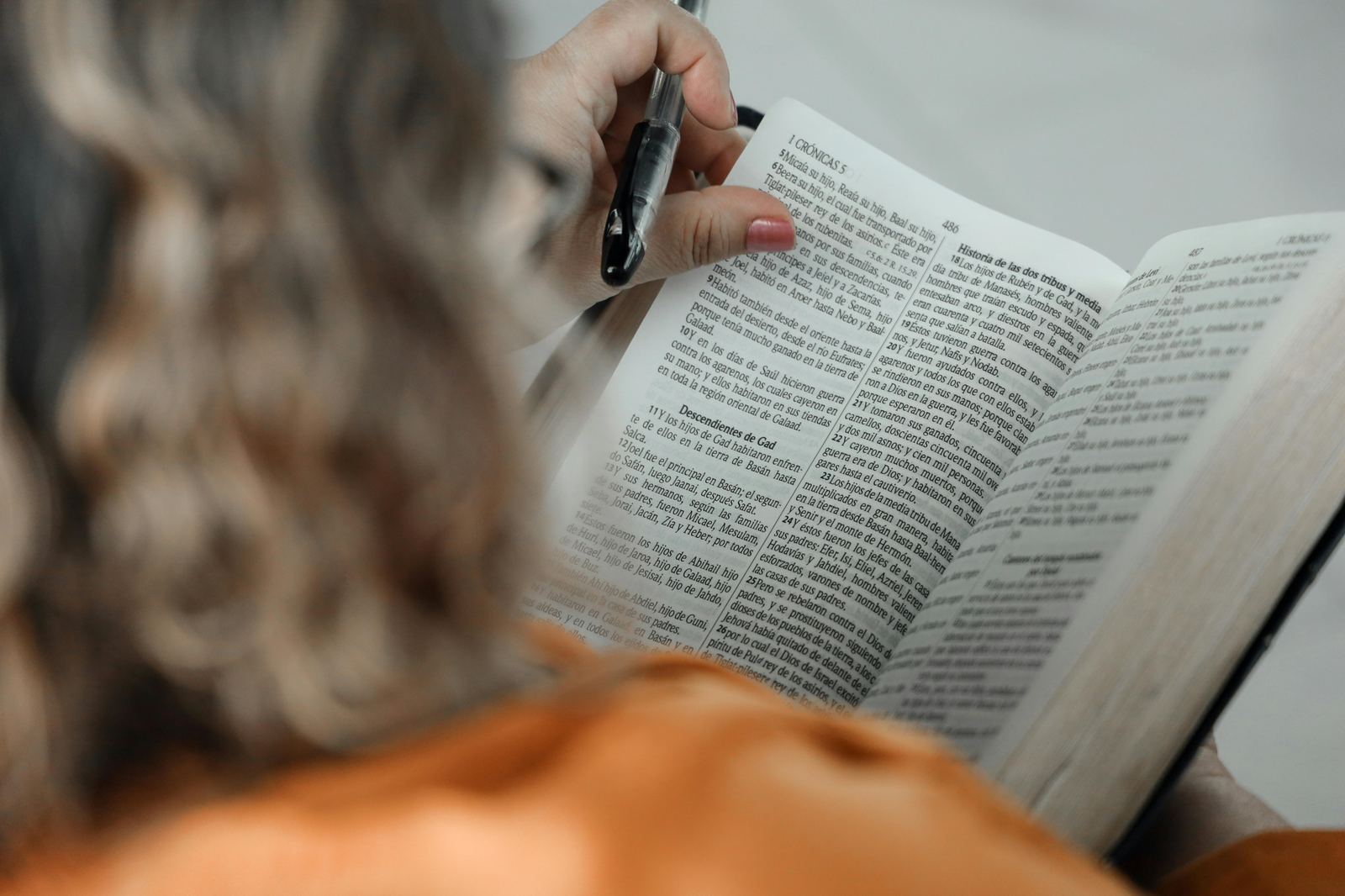 A person reading and writing in a Bible