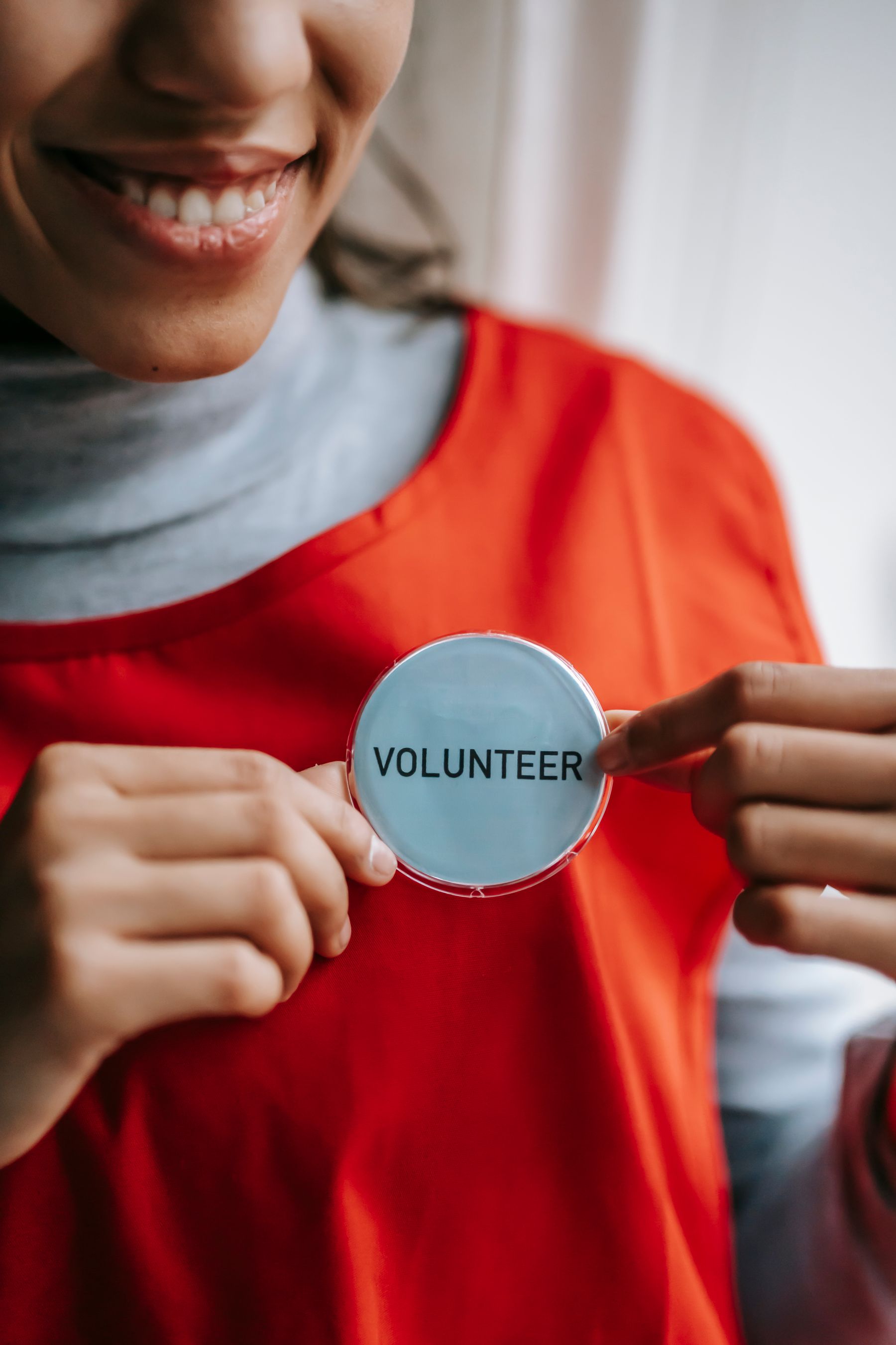 A smiling volunteer wearing a red apron