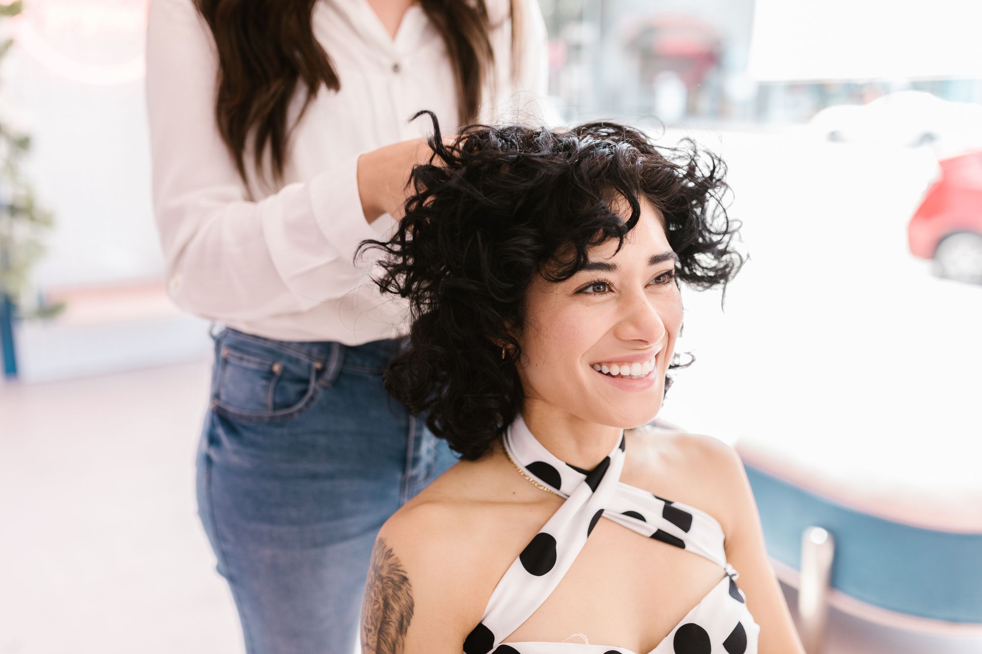 A smiling client having her curly hair styled