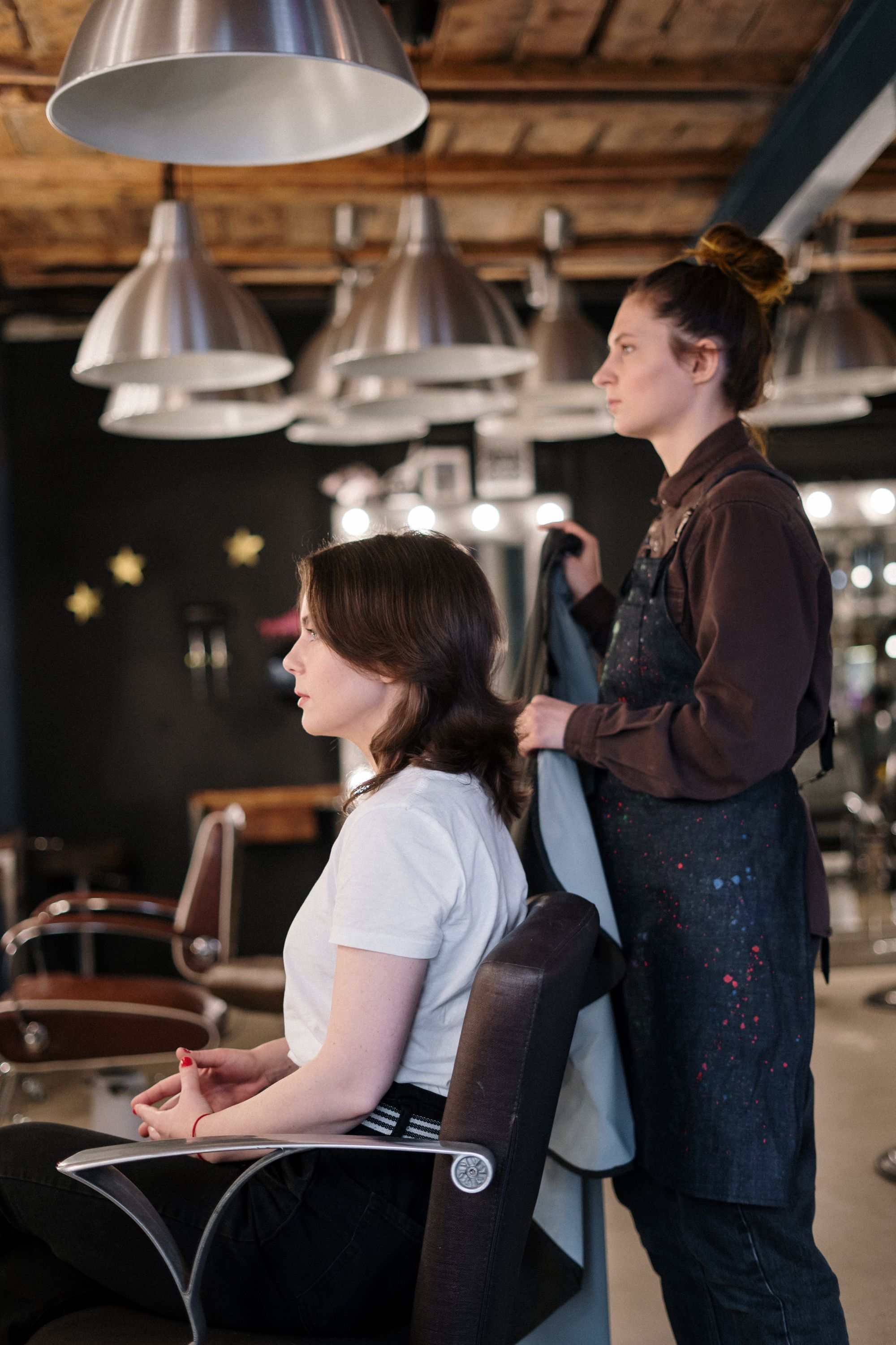 A stylist shaping a client's softly waved hair